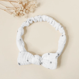 Detail of baby cotton gauze headband with star and moon prints and large bow design