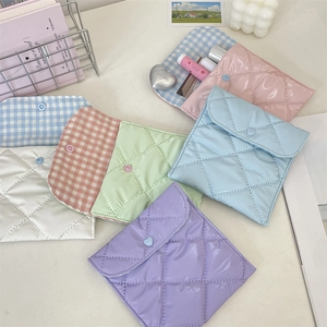 Flat lay of quilted mini sanitary storage bags in pastel colors with button closures
