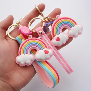 Close-up of pink silicone rainbow and cloud keychains with golden metal rings