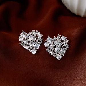 Detailed close-up of silver heart-shaped stud earrings with sparkling cubic zirconia