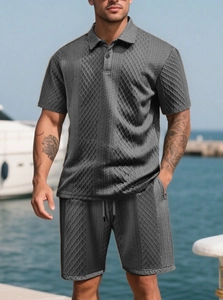 Detail of men's charcoal jacquard polo set showing diamond textured fabric and drawstring