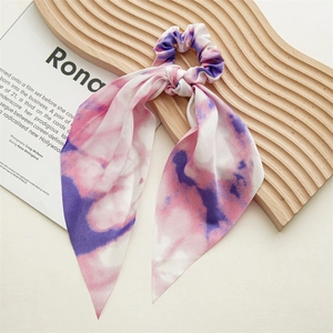 Detail of pink and purple tie-dye ribbon scrunchie on decorative tray for hair styling
