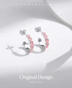 Close-up of S925 sterling silver C-shaped hoop earrings with pink enamel hearts
