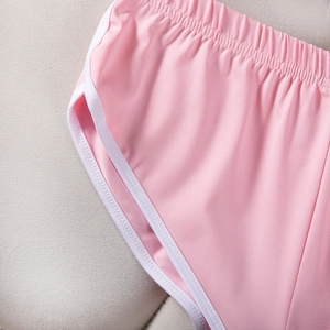 Detail der rosa Sportshorts mit elastischem Bund und weißer Paspelierung am Saum