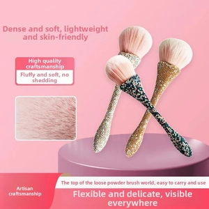 Detail of pink fluffy makeup brush head with rhinestone studded handle and macro texture