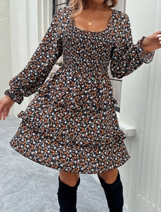 Close-up of floral dress featuring square neck, puff sleeves, and tiered ruffle hemline