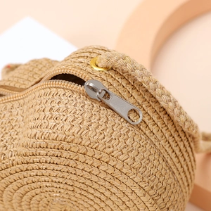 Detailed close-up of spiral woven straw pattern and zipper closure on a mini beach bag