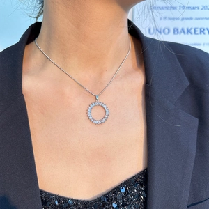 Nahaufnahme einer silbernen Halskette mit rundem Zirkonia-Anhänger an einer Schlangenkette