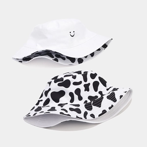 Reversible bucket hat with smiley face embroidery and cow print pattern for outdoor sun protection