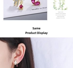 Detail of asymmetrical bear earrings with red heart crystals on a model and card