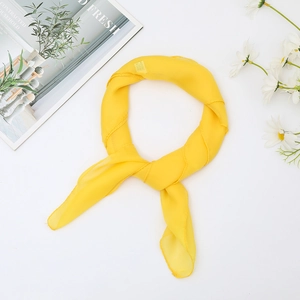 Yellow solid chiffon silk scarf 65x65cm for women shown with fresh flowers on white background