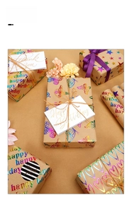 Detail of kraft gift wrapping paper with metallic foil heart and butterfly patterns