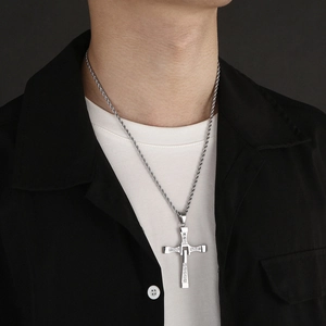 Silver cross pendant necklace with diamonds on a twisted chain worn by a model