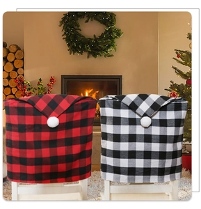 Detail of red and black buffalo plaid chair covers with pom-pom in festive home setting