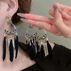 Détails de boucles d'oreilles bohèmes avec longues plumes noires et métal bronze vintage