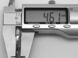 Detailed measurement of the 4.61 mm width of vintage medallion necklace using digital calipers
