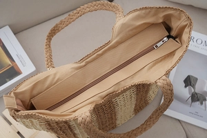Internal view of vertical striped straw tote bag showing zipper closure and cotton lining