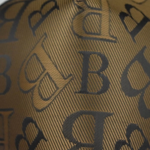 Macro view of woven houndstooth fabric with repeating black B letter monogram pattern
