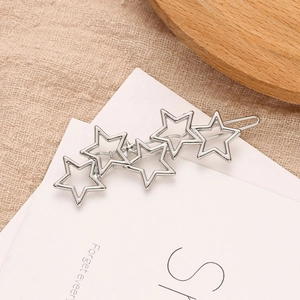 Polished silver alloy hair clip featuring connected hollow five-pointed stars on white card