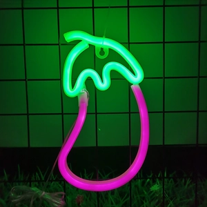 Eggplant LED neon light with pink fruit and green leaf on black grid background