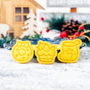 Christmas cookie cutters set featuring wreath and snowman shapes on festive wood background
