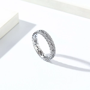 Macro detail of silver titanium steel ring with textured chain and X-shaped pattern