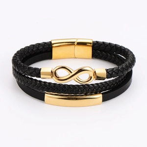 Détail d'un bracelet multicouche en cuir noir avec symbole infini doré et fermoir magnétique