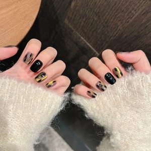 Cat eye press-on nails with black and gold foil shimmer in a short square shape