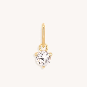 Detailed close-up of a single round zircon inlaid in a three-prong gold plated setting