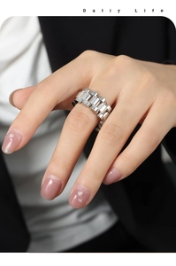Detail of a gold-plated watchband style ring worn with a professional suit and shirt