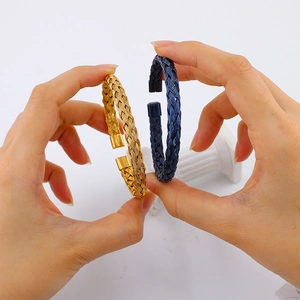 Detail of twisted cable wire cuff bracelets in gold and blue stainless steel finish