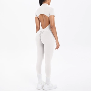 Detail of white short sleeve yoga jumpsuit featuring an open back cutout and ruched butt lift