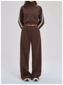 Detail of a brown zip-up cropped sweatshirt and matching wide-leg pants with side stripes