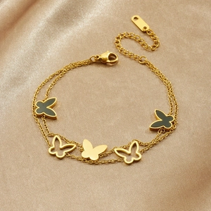 Double-layered gold butterfly bracelet with black enamel charms on elegant silk fabric