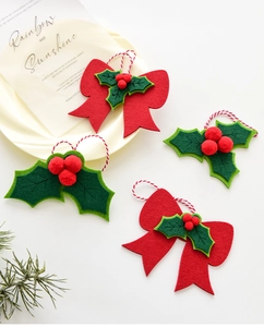Detail of felt Christmas bow and holly leaf hanging ornaments with spiral lanyard