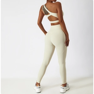 Détail du dos croisé ajouré sur le haut de yoga asymétrique crème et le legging taille haute
