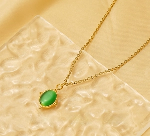 Detail of 18K gold stainless steel sun pendant with oval green cat eye stone inlay