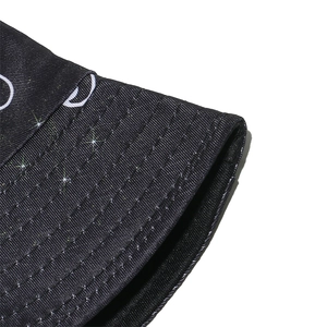 Vue macro détaillée du motif lune blanche et étoiles sur le tissu du chapeau bob noir