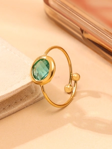Makroaufnahme von 18k vergoldetem offenem Ring mit grünem ovalem Glasstein-Detail