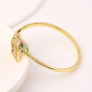 Detail of gold-plated leaf bangle featuring colorful rainbow zircon stones and open design