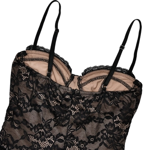 Detail shot of black floral lace fabric with beige lining and adjustable shoulder straps