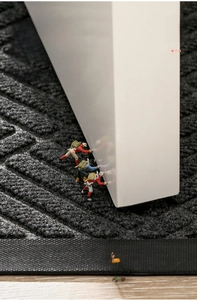 Macro shot of thin dark grey doormat showing slim profile for easy door clearance