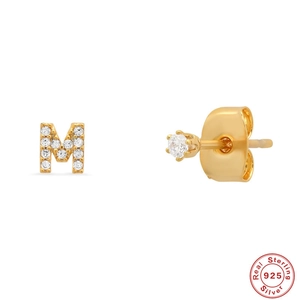 Close-up of S925 sterling silver gold stud earring with letter M and clear gemstone