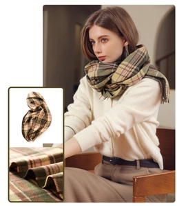 Close-up of soft plaid scarf fabric with tassel fringe details and warm winter colors