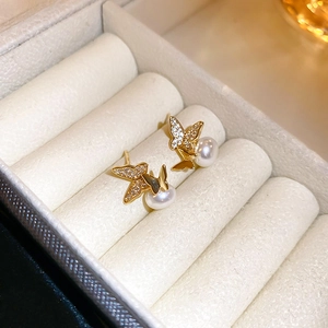 Detail shot of elegant butterfly pearl earrings with gold plating and zircon inlay