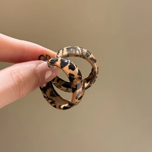 Vue détaillée des boucles d'oreilles en résine léopard montrant texture et design