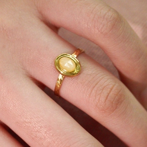 Macro shot of gold plated stainless steel ring featuring a faceted oval orange natural stone