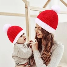 Matching red and white winter knitted beanies worn by a mother and her baby