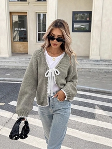 Sage green knitted cardigan with white lace trim and bow ties in casual street style