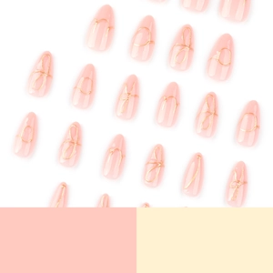 Elegant almond shaped press on nails with 3D gold wire bow design on soft pink base